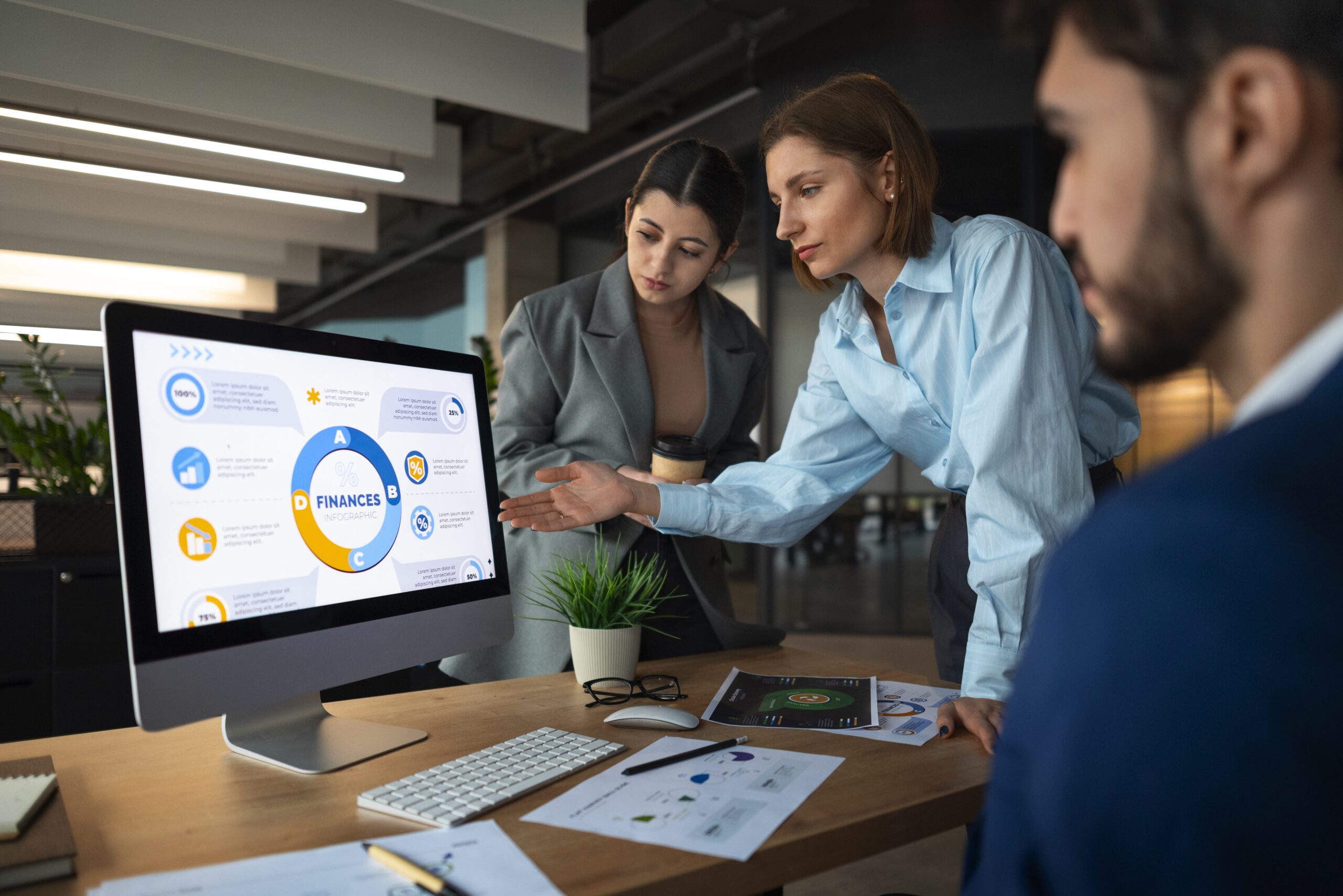 Your trusted financial partner at work Professional financial partner reviewing client reports in a modern office while team members collaborate in the background.