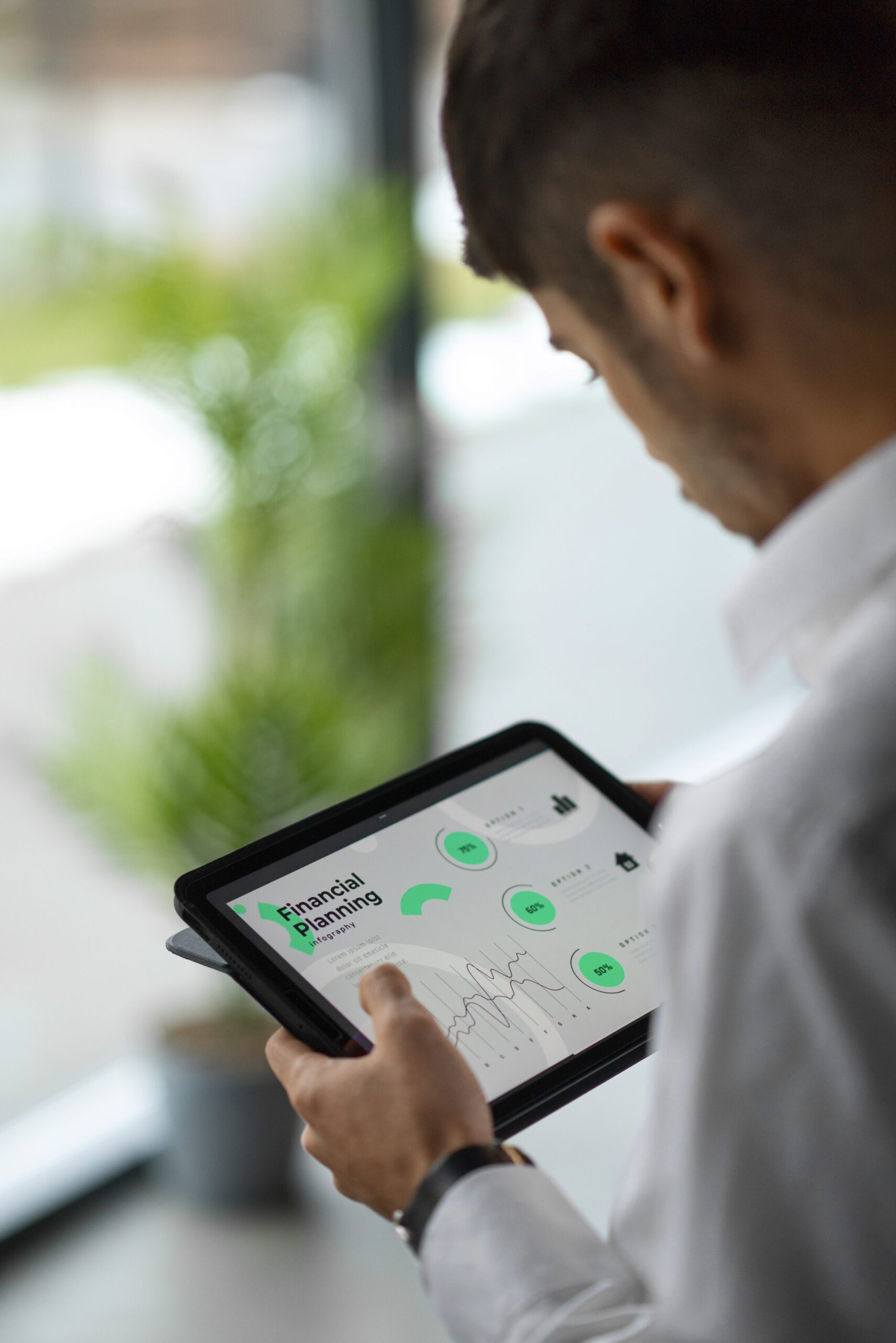 obsidian-financial-planning-insights-tablet Man analyzing financial planning data on a digital tablet in a modern office environment